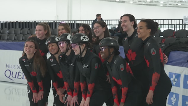 De jeunes patineuses de vitesse sourient pour un photographe.