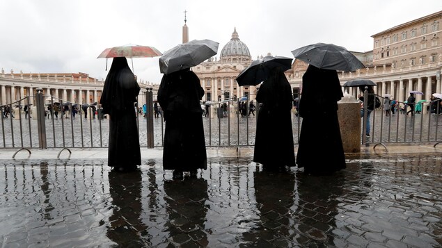 Des religieuses s'abritent sous des parapluies à la place Saint-Pierre au Vatican