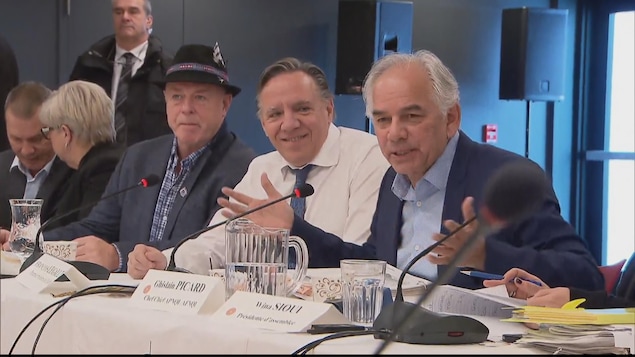 François Legault est souriant pendant qu'il écoute Ghislain Picard prendre la parole.