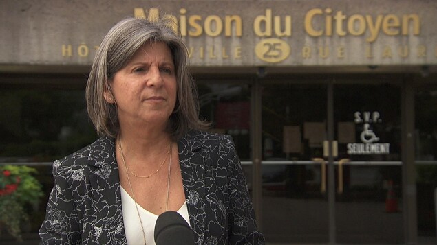 Renée Amyot répond aux questions de journalistes à l'extérieur de l'hôtel de ville.