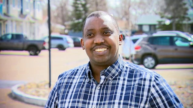 Renord Nsekera tout souriant devant la caméra, dehors, par une journée de printemps.