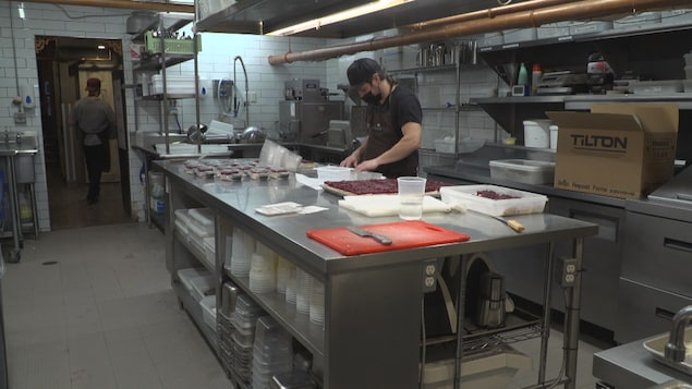 Un employé à l'œuvre dans la cuisine du restaurant Chez Rioux & Pettigrew.