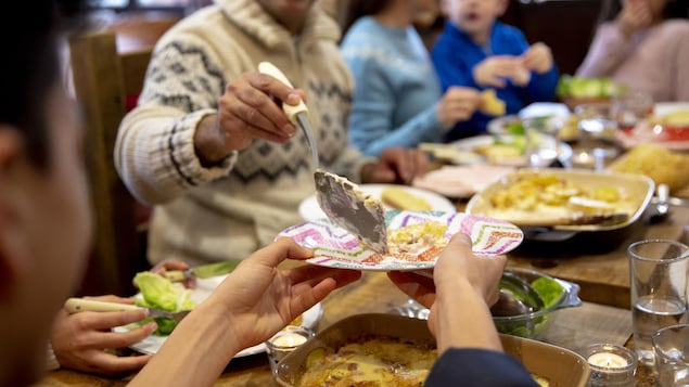 Un homme sert un invité lors d'un souper.