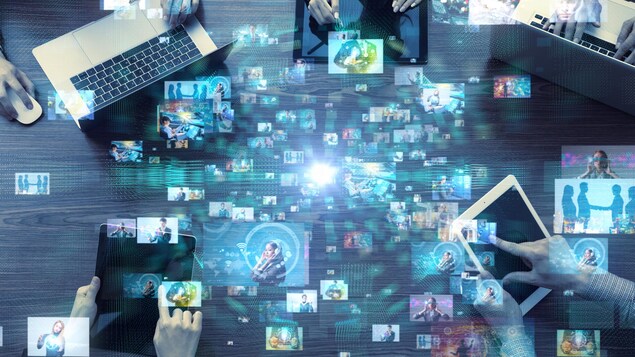 on voit des gens sur les ordinateurs et tablettes qui échangent de l'information.