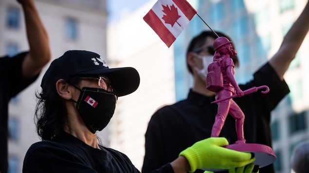 在溫哥華支持香港人抗議活動中，有人展示高舉加拿大國旗的香港自由女神迷你塑像。