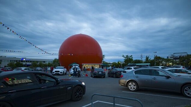 Le restaurant en forme d'orange géante, avec des voitures dans son stationnement.