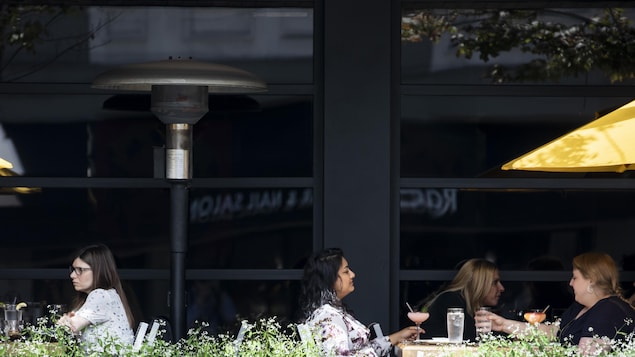 Des clientes mangent sur la terrasse du Cactus Club Café à Vancouver, en Colombie-Britannique.
