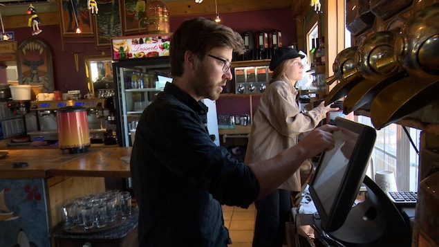 Un serveur devant un écran tactile dans un restaurant