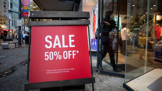 A sign announcing a 50% off sale outside a store on Black Friday.