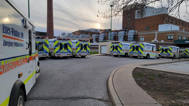 Des ambulances attendent devant un hôpital.