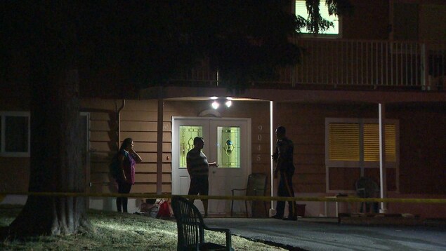 On voit un agent de la police parler au voisinage le soir. On voit un agent de la police parler au voisinage le soir.