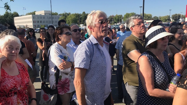 Richard Desjardins se tient dans une foule. Richard Desjardins se tient dans une foule.