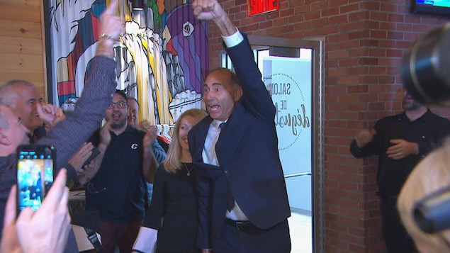 Richard Martel lève le bras en l'air en signe de victoire.