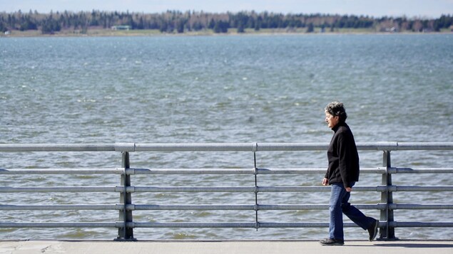 Une femme marche sur la Promenade de la mer, à Rimouski.
