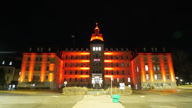Le bâtiment de l'Université du Québec à Rimouski, éclairé de rouge.