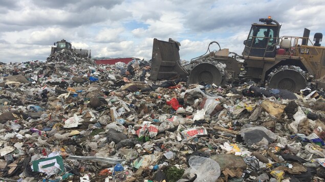 Des camions enfouissent les déchets sur le site d'enfouissement à Lachenaie.