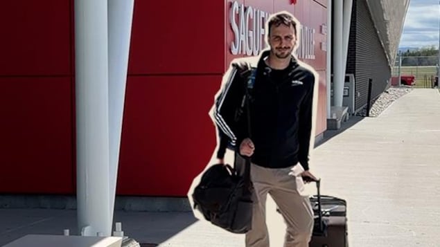 Un homme tire une valise en marchant.