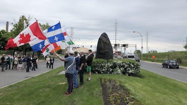 Des hommes brandissent, près de la Roche noire, des drapeaux canadien, québécois, montréalais et irlandais. Des hommes brandissent, près de la Roche noire, des drapeaux canadien, québécois, montréalais et irlandais.
