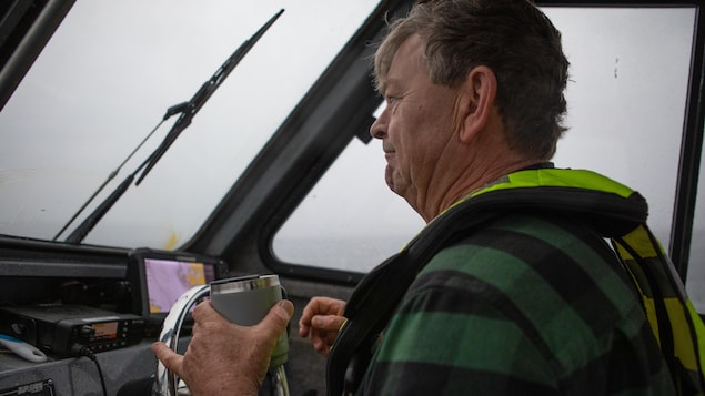 Roger Dunlop conduit un bateau, une tasse à la main, près de l’île Nootka, en Colombie-Britannique, fin octobre 2023.