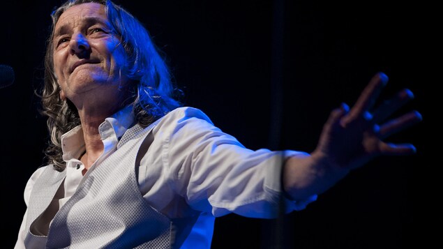 Le chanteur salue de la main gauche. Le chanteur salue de la main gauche.