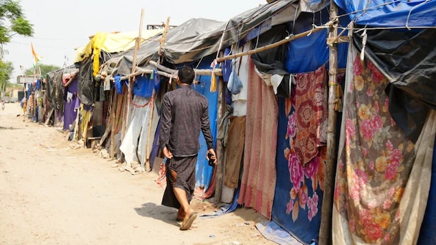 A man walks past rows of makeshift tents at the New Delhi camp where more than 50 families of Rohingya refugees live, amid growing fears they will be deported. (Salimah Shivji/CBC)