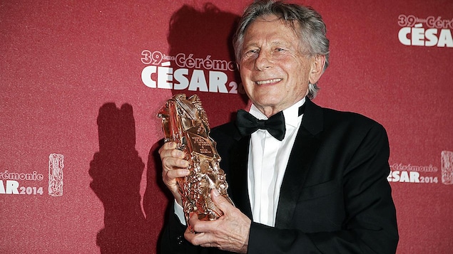 L'homme tient un trophée.