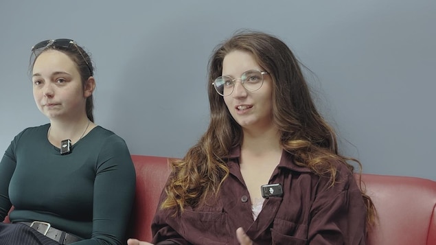 Deux jeunes femmes assises sur un divan
