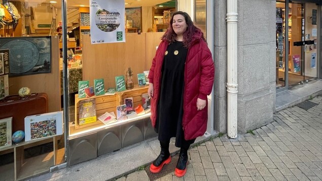 Une femme devant la vitrine d'une librairie, en France. 