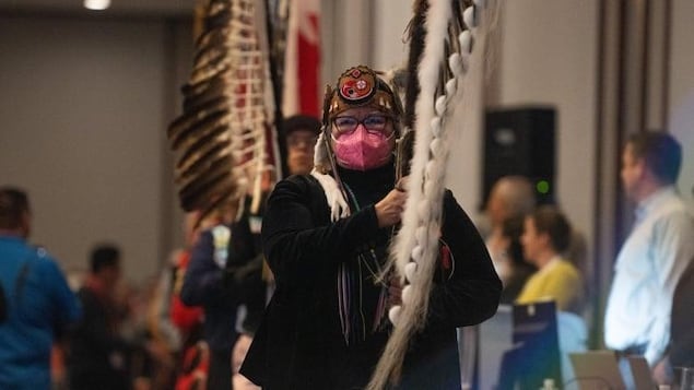 A woman holding a ceremonial staff.