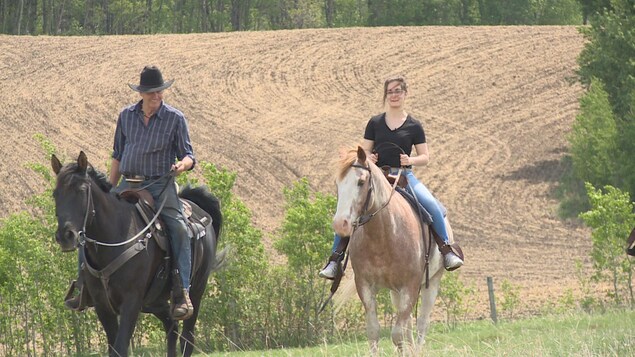 Deux personnes font de l'équitation.