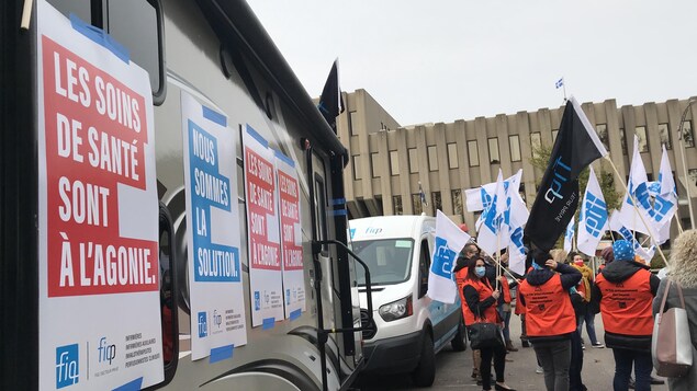 Des manifestants devant la roulotte du FIQ.