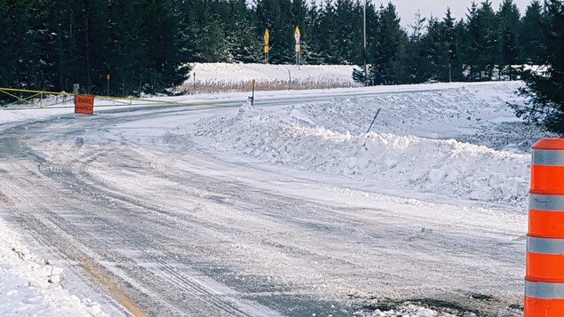 Cône orange indiquant une route fermée en hiver