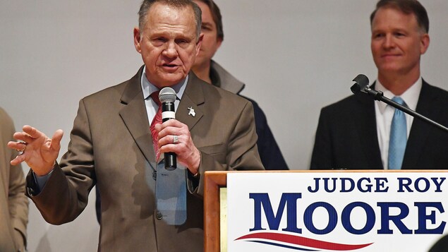 Roy Moore parle au micro devant un lutrin. Roy Moore parle au micro devant un lutrin.