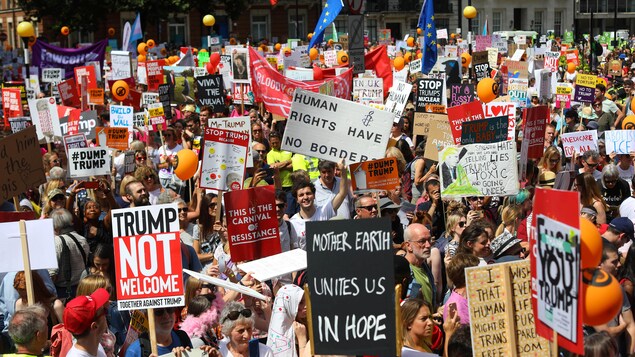 Une marée de manifestants et de pancartes dénonçant la venue de Trump. Une marée de manifestants et de pancartes dénonçant la venue de Trump.