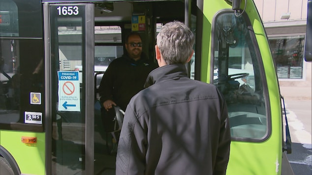 Un homme monte à bord d'un autobus du Réseau de transport de la Capitale à Québec le 14 mai 2020.