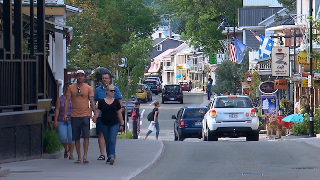 Des gens marchent le long d'une rue commerciale