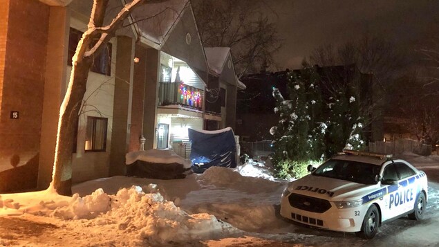 Une voiture de police près d'un édifice de logements à Gatineau la nuit.