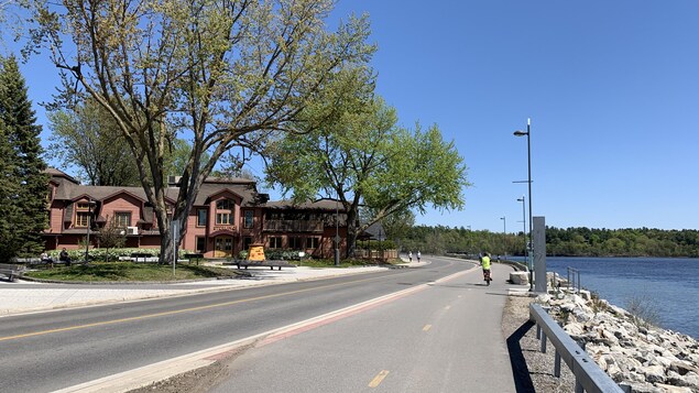 Des voitures et un cycliste se déplacent sur la chaussée.