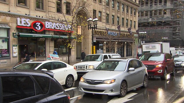 Des voitures sur la rue Sainte-Catherine devant des commerces