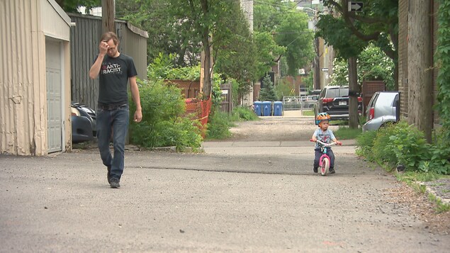 Un homme et son enfant circule dans une ruelle de Limoilou à Québec.
