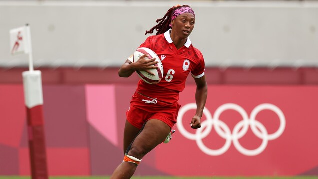 Charity Williams, de l'équipe canadienne, court avec le ballon dans les bras.