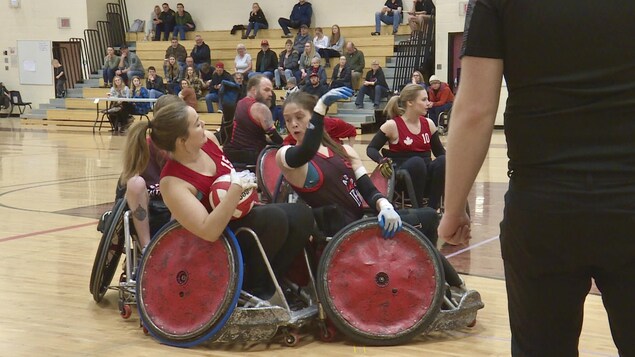 Des personnes en fauteuils roulants participent à un match de rugby.