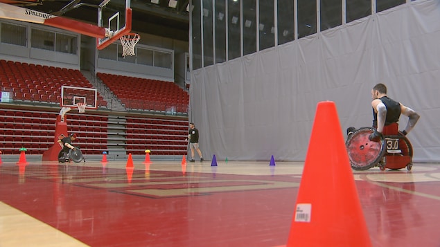 Des joueurs de rugby en fauteuil roulant à l'entraînement dans un gymnase de l'Université Laval.