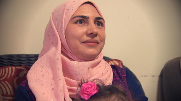 une femme voilée tient une petite fille sur ses genoux. une femme voilée tient une petite fille sur ses genoux.