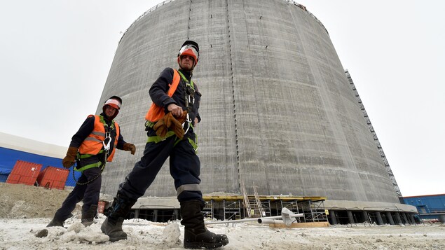 Des employés marchent près d'un réservoir de gaz naturel dans la péninsule de Yamal en Russie. Des employés marchent près d'un réservoir de gaz naturel dans la péninsule de Yamal en Russie.