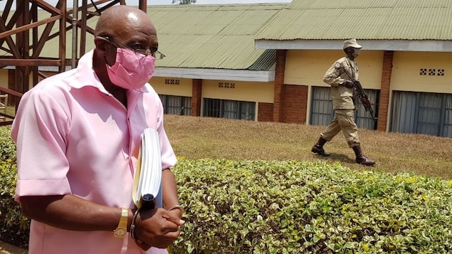 Clad in a pink prison uniform, Paul Rusesabagina, who was portrayed as a hero in the movie Hotel Rwanda about the country's 1994 genocide, is escorted in handcuffs from a courtroom in Kigali, Rwanda, in this September 2020 photo.