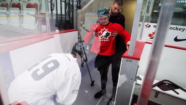 Ryan Straschnitzki reçoit de l'aide pour monter sur la glace. Ryan Straschnitzki reçoit de l'aide pour monter sur la glace.