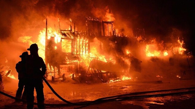 Deux pompiers combattent l'incendie de la Résidence du Havre de L'Isle-Verte, près de Rivière-du-Loup, qui a fait 32 morts le 23 janvier 2014.