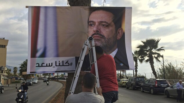 Des travailleurs posent une affiche sur un arbre. Des travailleurs posent une affiche sur un arbre.