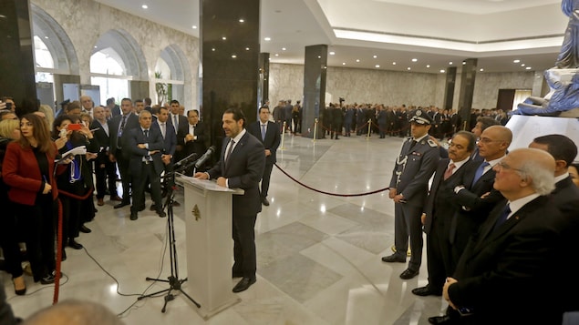 Saad Hariri, devant un lutrin, fait son allocution entouré par une foule de journalistes et de politiciens libanais. Saad Hariri, devant un lutrin, fait son allocution entouré par une foule de journalistes et de politiciens libanais.